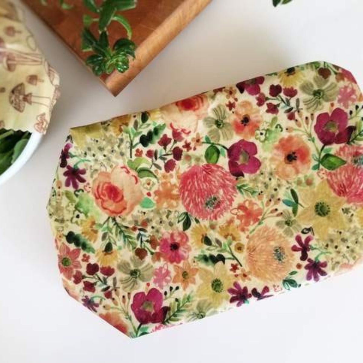 Extra large beeswax wraps with floral patterns laid out on a surface.